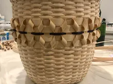 Finished tall cylindrical basket with a textured twill center band and a dark accent stripe, standing on a marble counter.