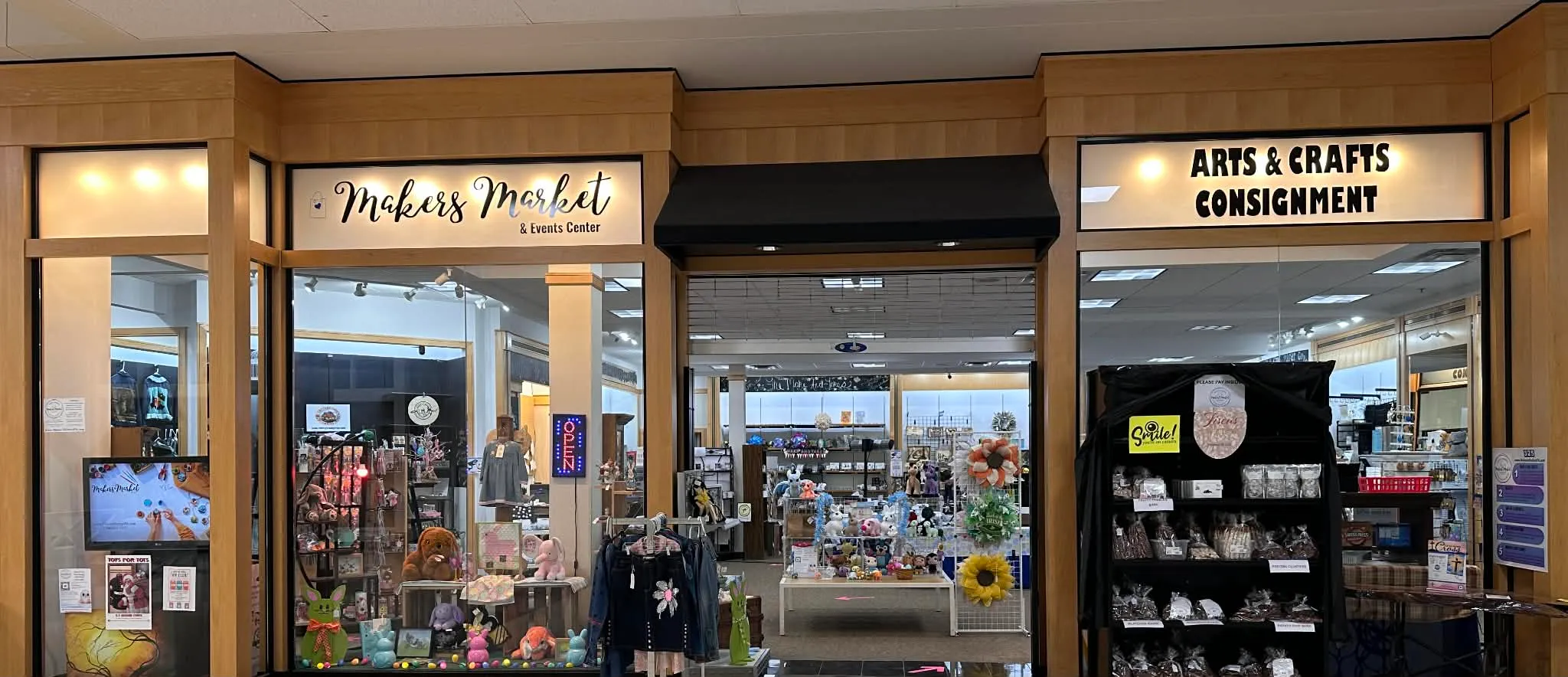 The Makers Market and Events Center storefront inside Clearview Mall, with a lit script sign over the left window and an Arts and Crafts Consignment sign on the right.